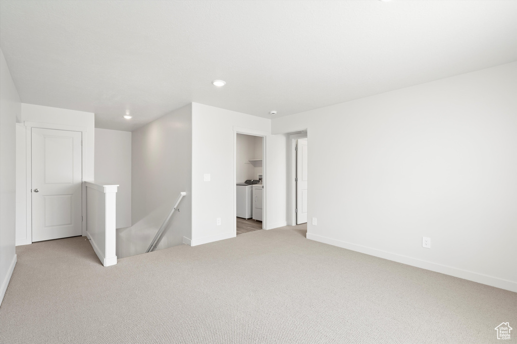 Carpeted empty room featuring separate washer and dryer and recessed lighting