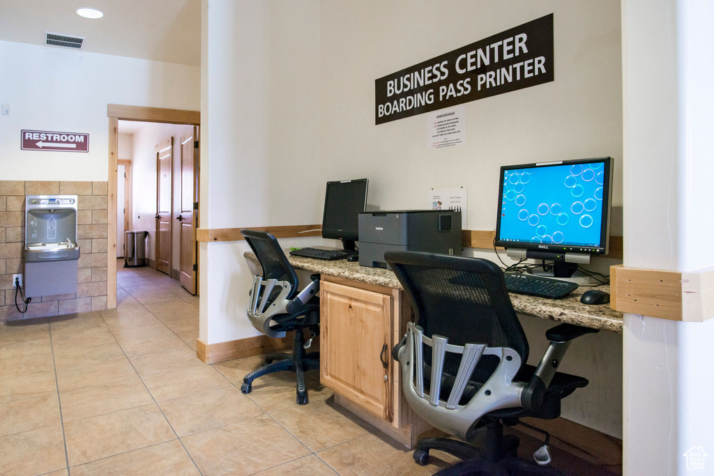 Office with built in desk, visible vents, and light tile patterned floors