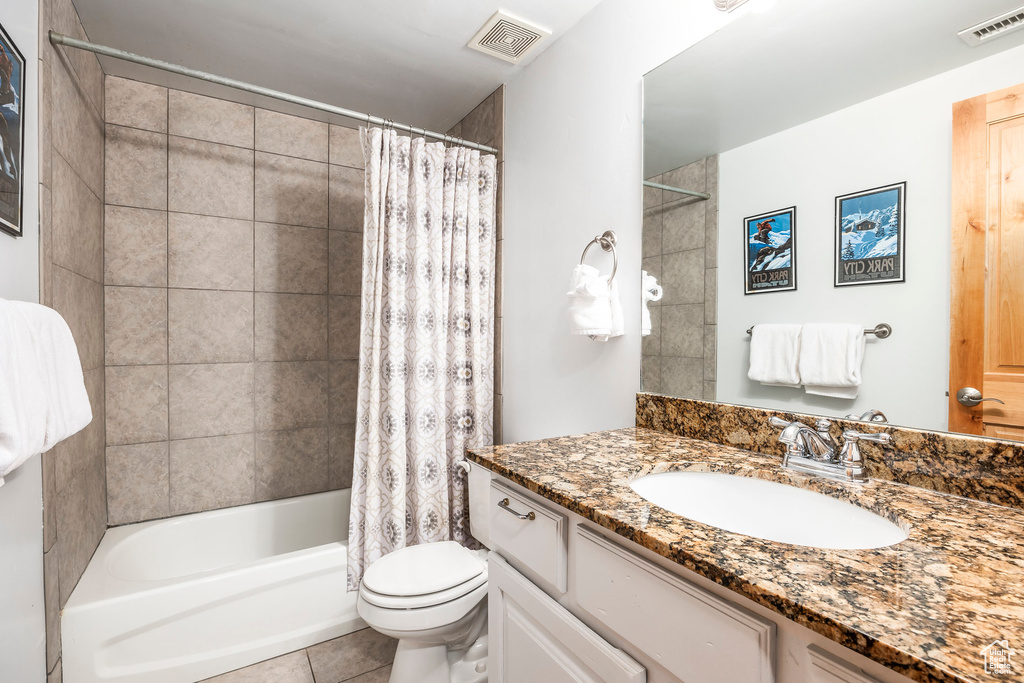 Bathroom featuring tile patterned floors, vanity, toilet, and visible vents