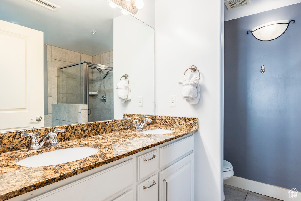Bathroom featuring visible vents, a sink, tile patterned flooring, and a stall shower