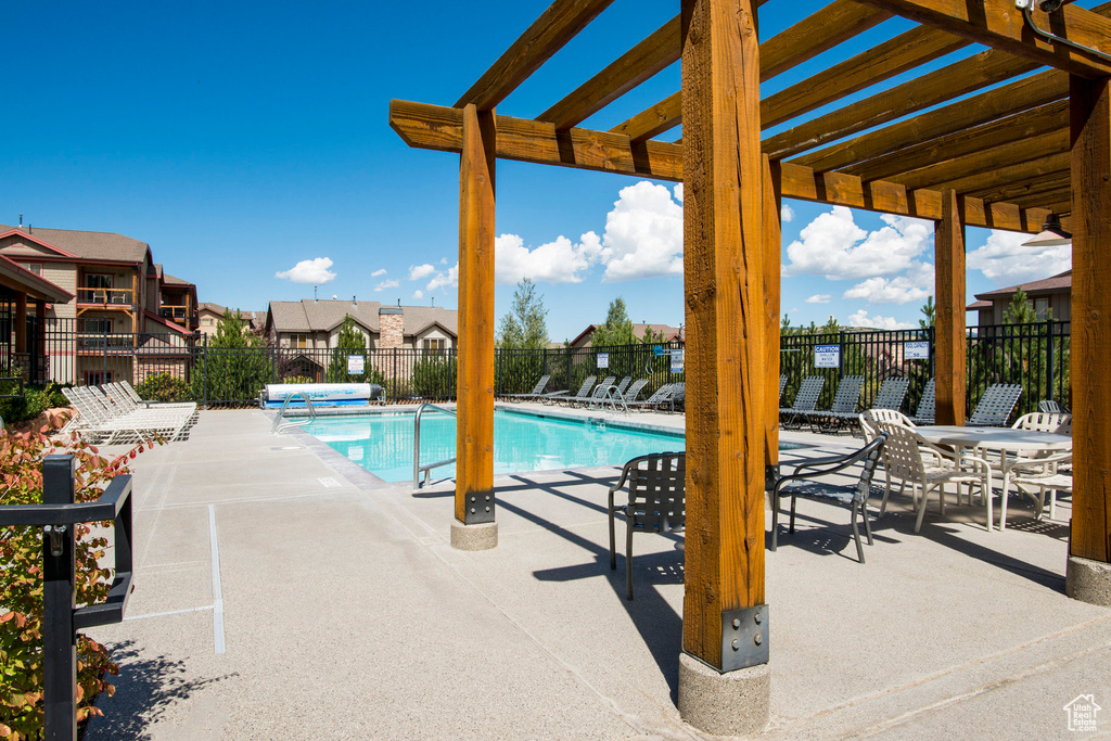 Pool featuring fence, a patio, a pergola, and a residential view