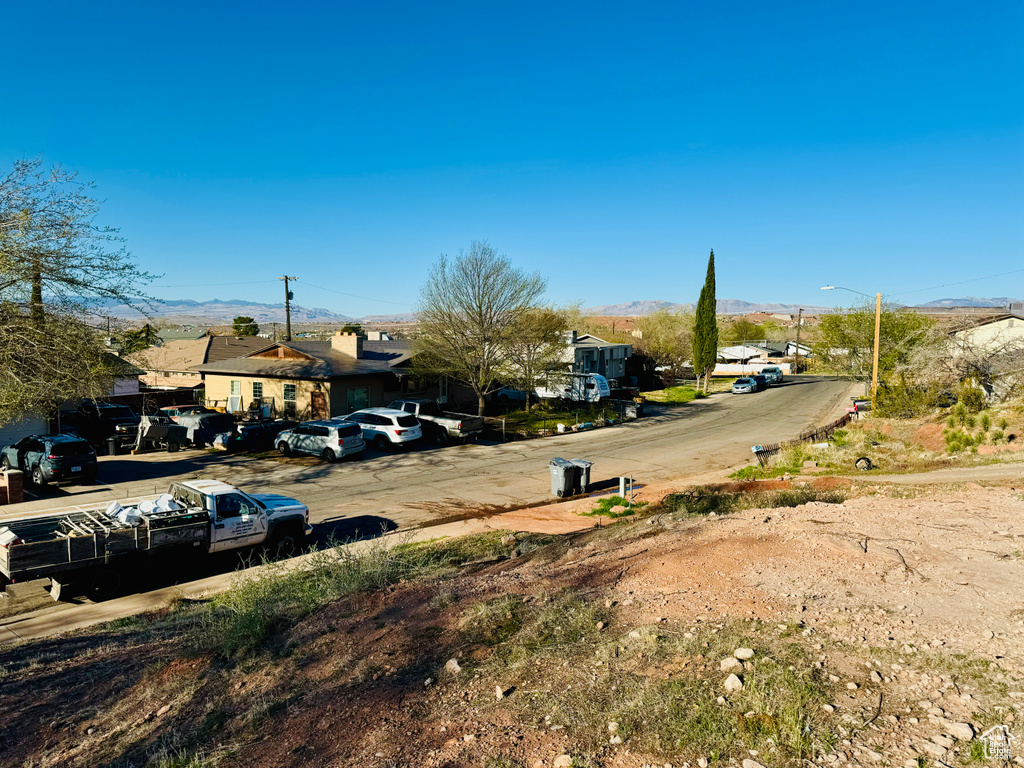 View of asphalt street featuring a mountain view, street lighting, and a residential view