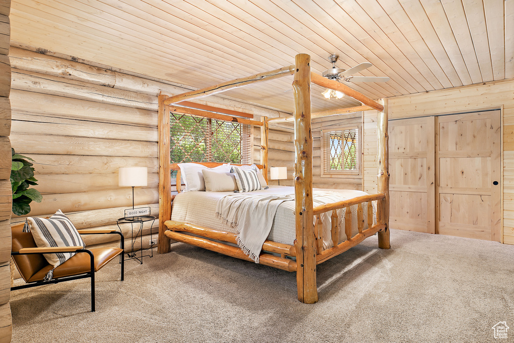 Bedroom featuring carpet, wooden ceiling, and rustic walls