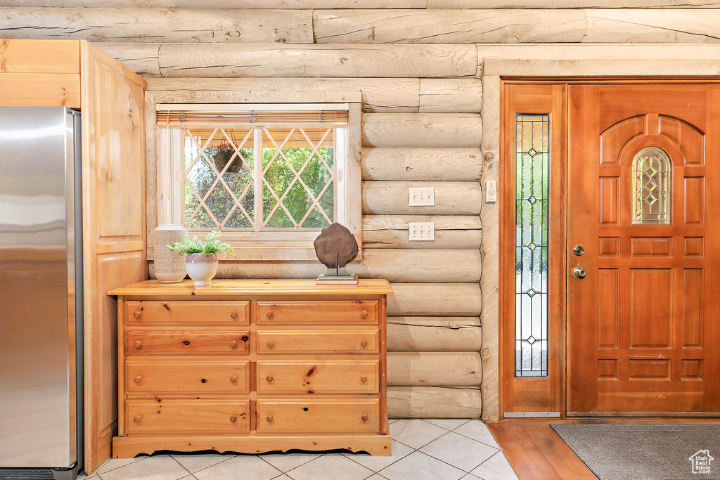 Foyer entrance featuring rustic walls