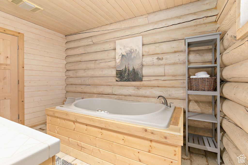 Bathroom featuring wood ceiling, log walls, visible vents, and a bath