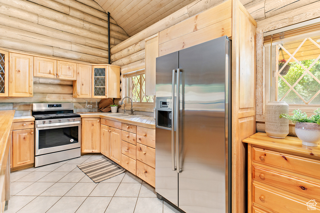 Kitchen with stainless steel appliances, light brown cabinetry, and a sink
