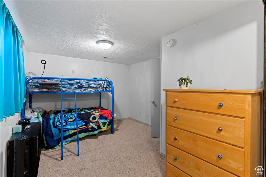 Carpeted bedroom featuring a textured ceiling