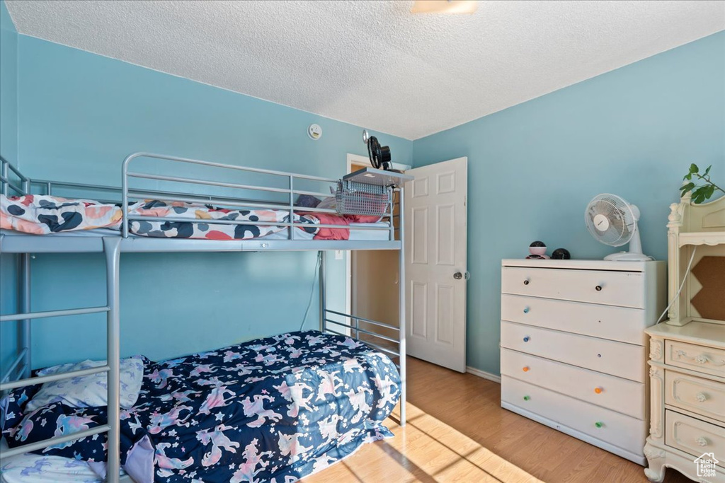 Bedroom featuring wood finished floors and a textured ceiling
