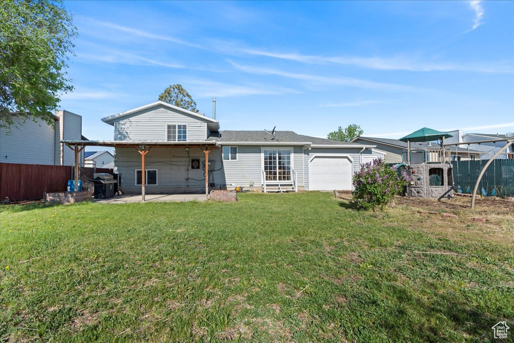 Back of property with a garage and a patio area
