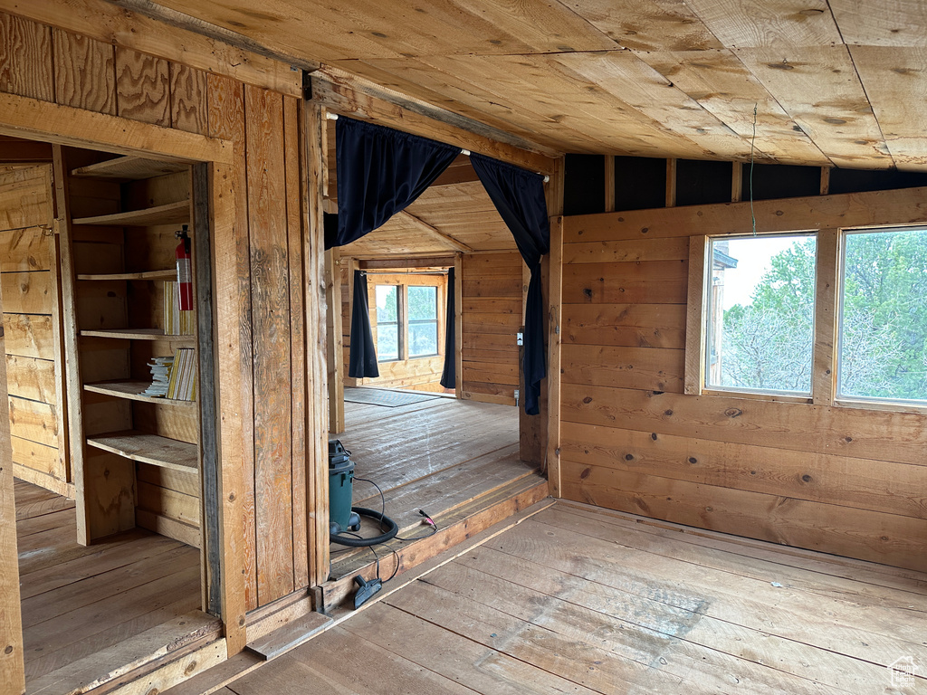 Spare room featuring wood walls, wood-type flooring, and wood ceiling