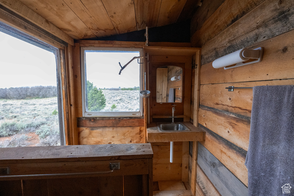 Sunroom featuring a sink and lofted ceiling