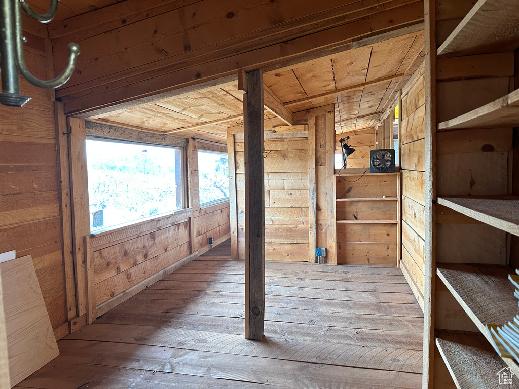 Hallway with wood walls and hardwood / wood-style flooring