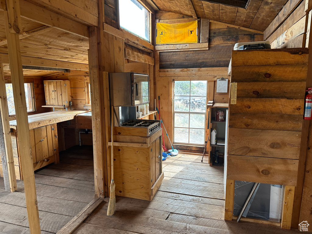 Interior space featuring lofted ceiling, light wood finished floors, and wooden walls