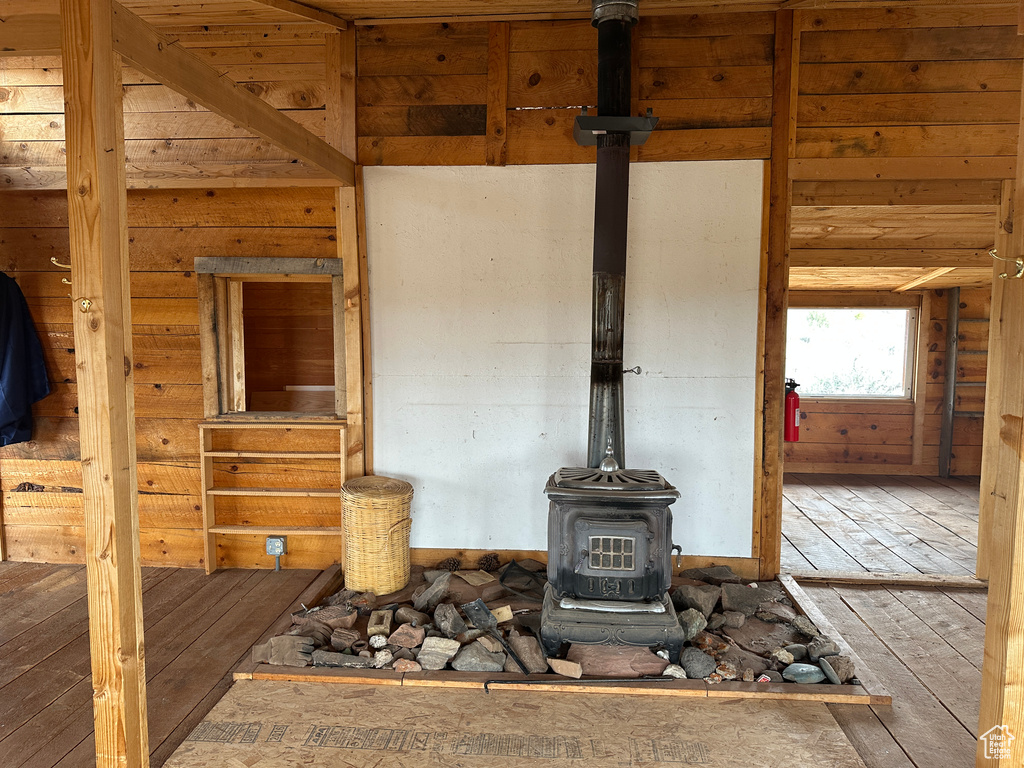 Detailed view of a wood stove, a fire extinguisher, wood finished floors, and wood walls