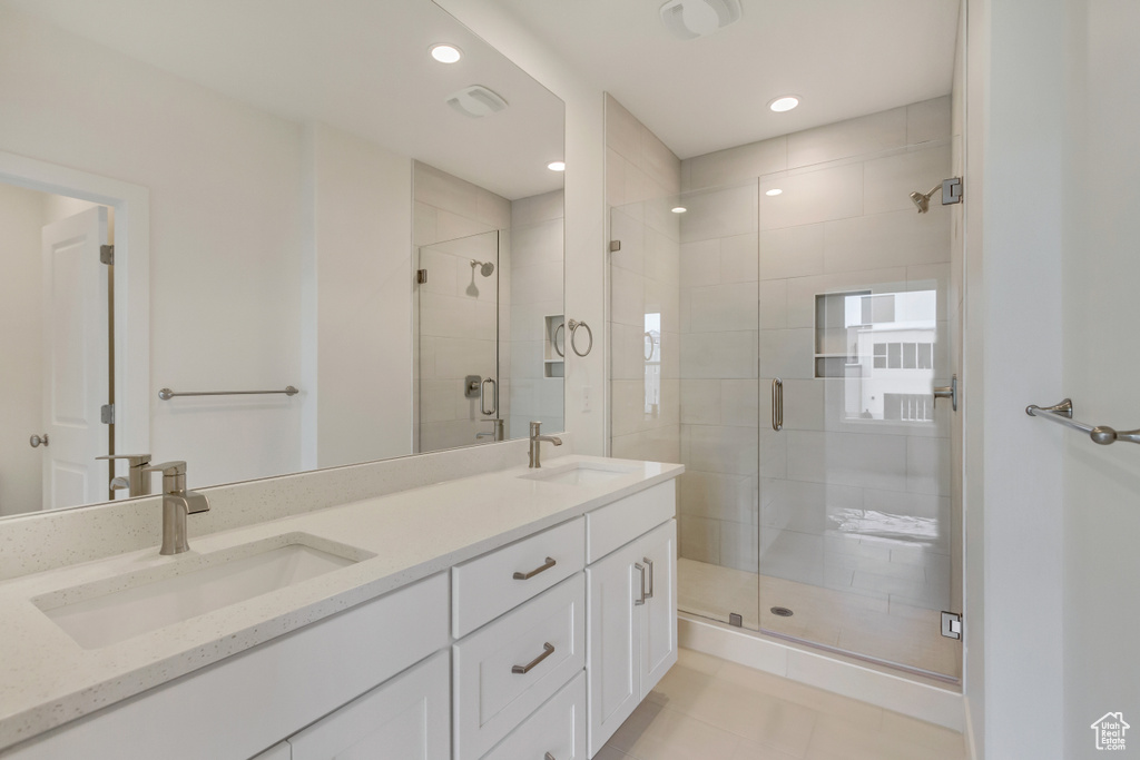 Full bathroom featuring a shower stall, double vanity, recessed lighting, and tile patterned flooring