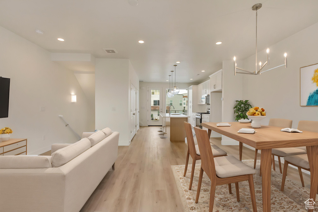 Dining space featuring recessed lighting, light wood-style floors, baseboards, and a chandelier