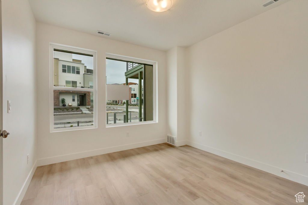 Spare room featuring light wood finished floors and baseboards