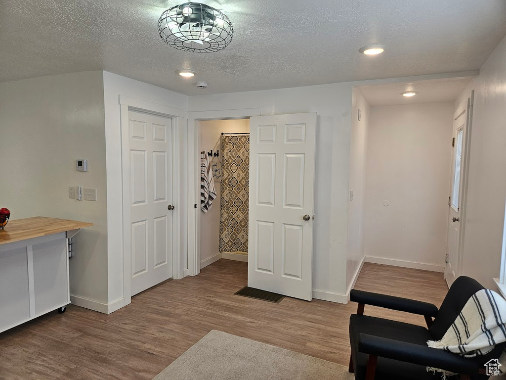 Living area featuring wood finished floors, baseboards, a textured ceiling, and recessed lighting