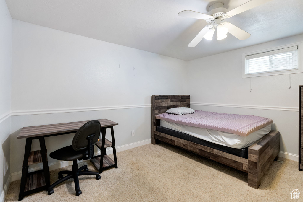 Bedroom featuring baseboards, a ceiling fan, carpet floors, and a desk