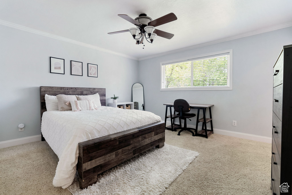 Bedroom featuring crown molding, baseboards, carpet flooring, and ceiling fan