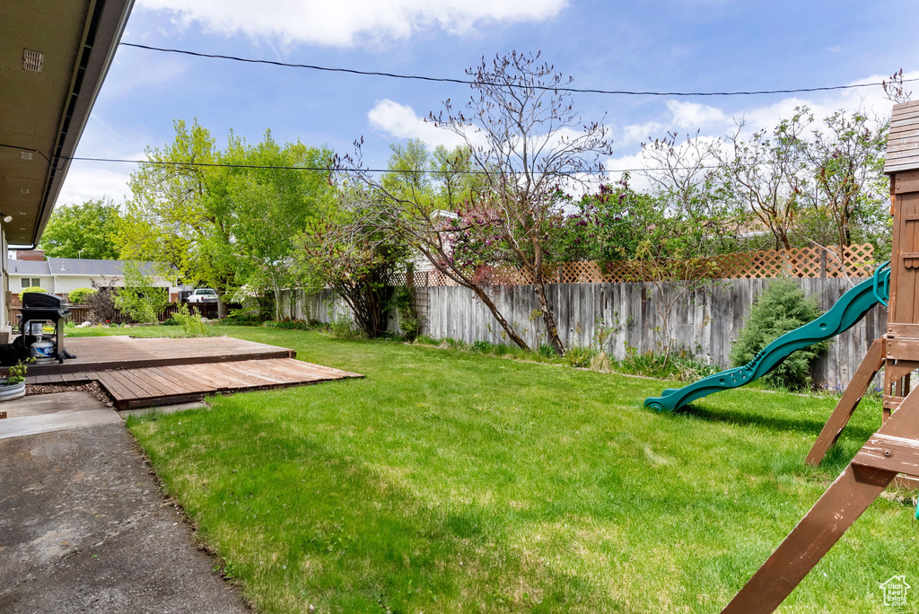 View of yard featuring a deck and a playground