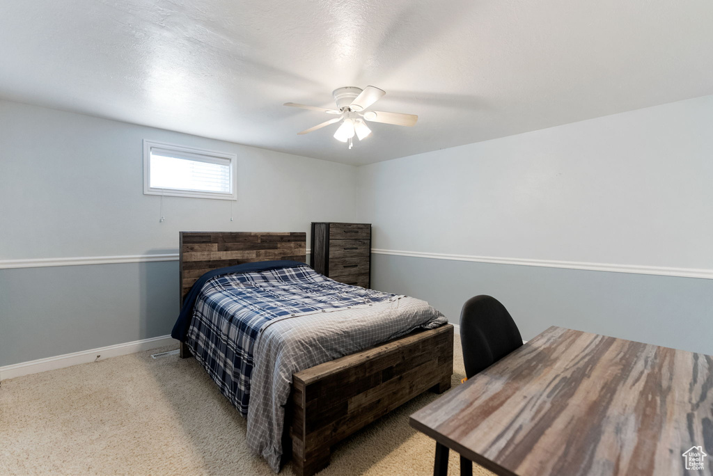 Carpeted bedroom featuring baseboards and a ceiling fan