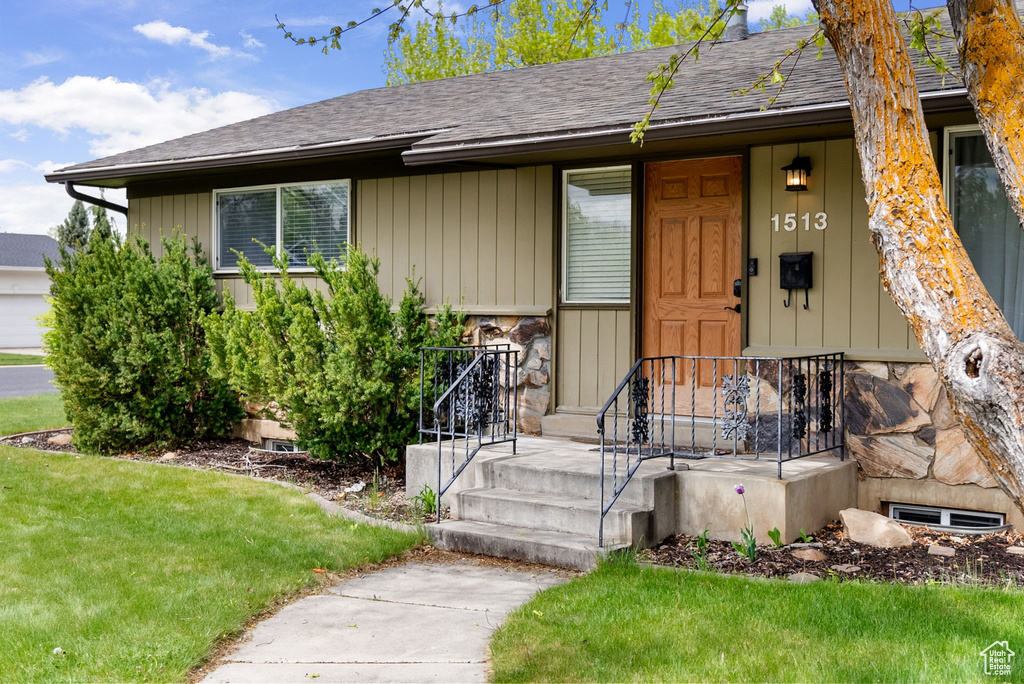 View of front of home featuring a shingled roof and a front lawn