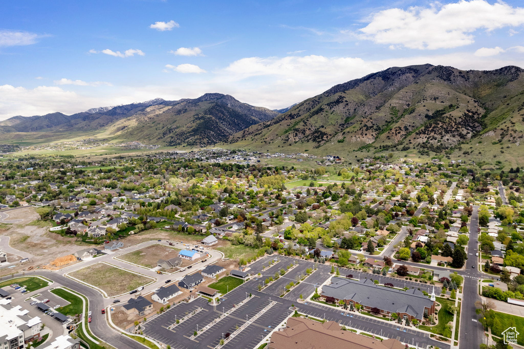 Aerial view of property and surrounding area with a mountainous background and nearby suburban area
