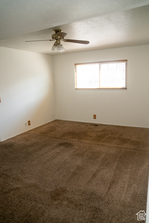 Carpeted spare room featuring ceiling fan