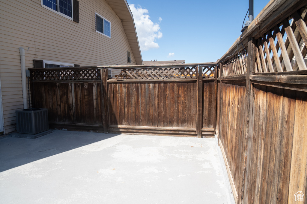 View of patio with cooling unit and fence