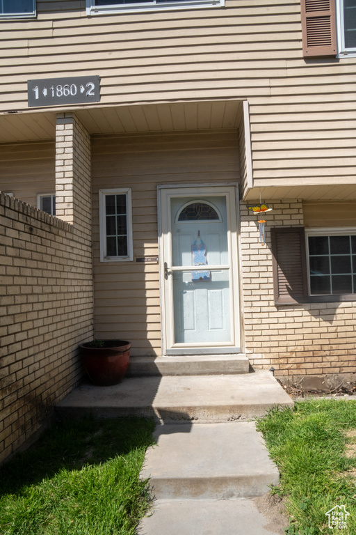 View of exterior entry with brick siding
