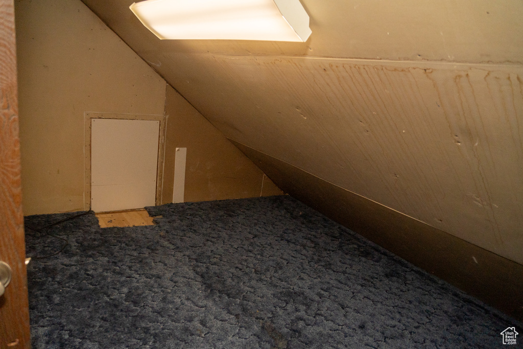 Bonus room featuring vaulted ceiling and carpet flooring