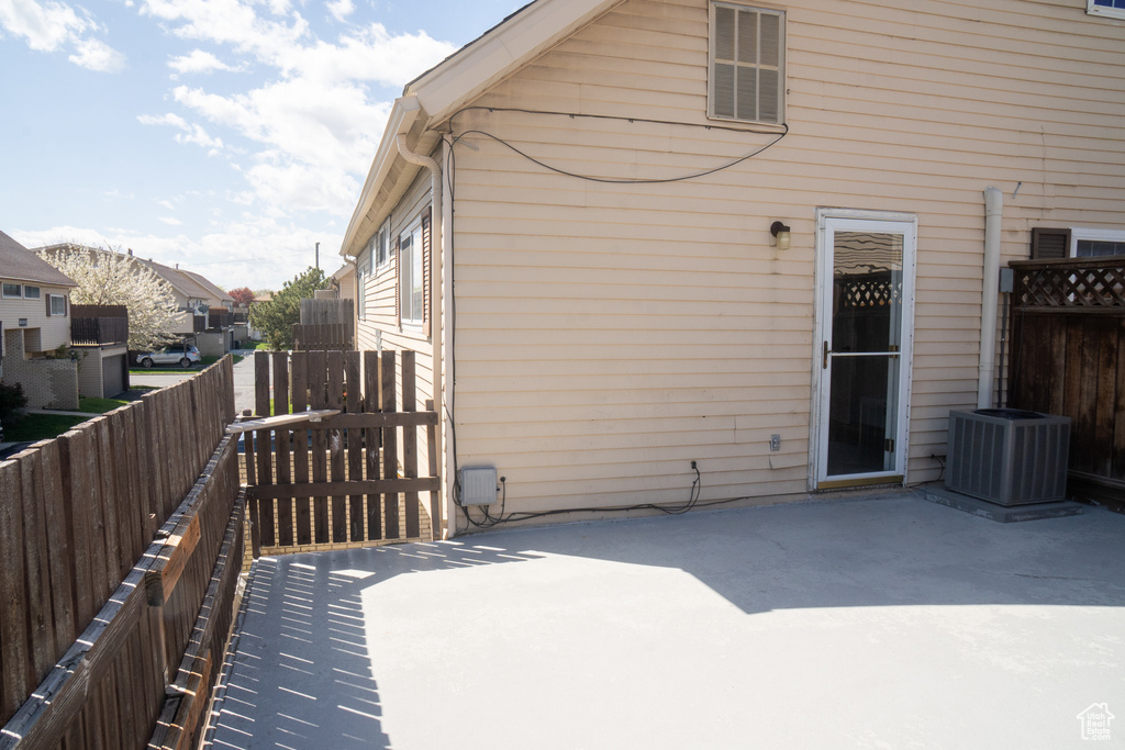 Rear view of house featuring a patio area, a fenced backyard, and central air condition unit