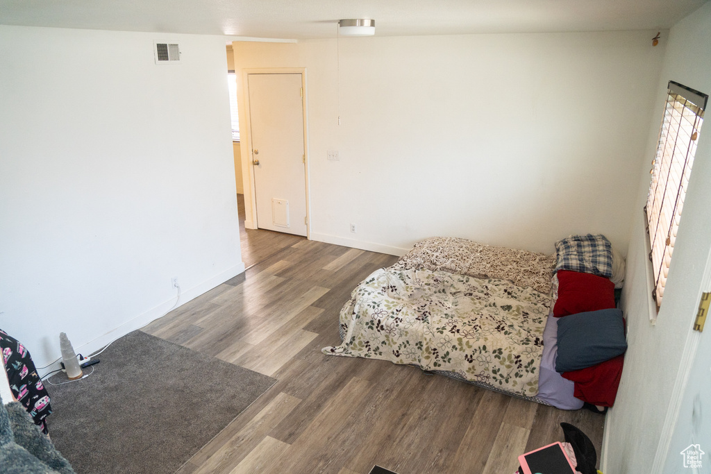 Bedroom with wood finished floors and baseboards