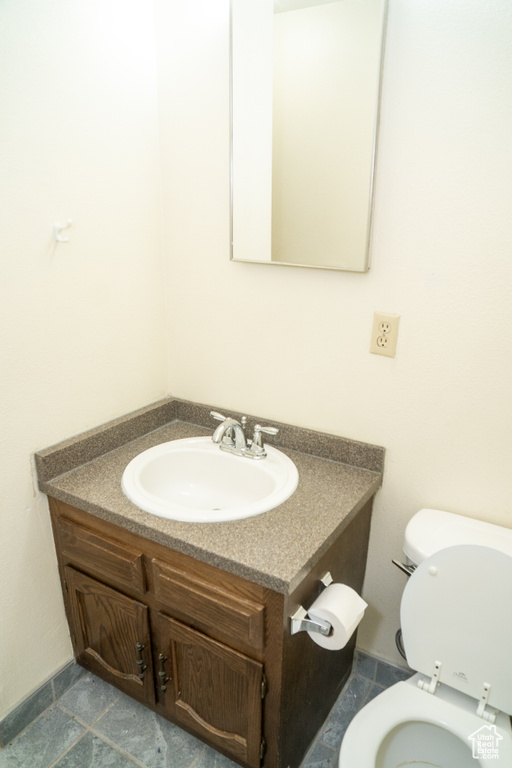 Bathroom with vanity, toilet, and tile patterned floors