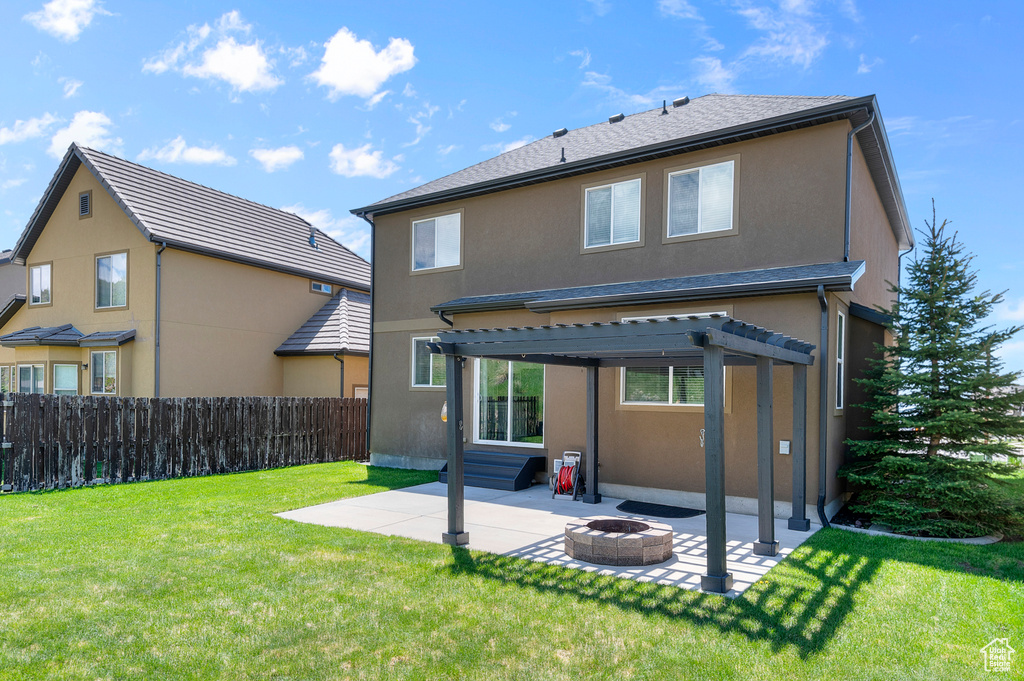 Rear view of property with a patio area, a pergola, a fire pit, and stucco siding