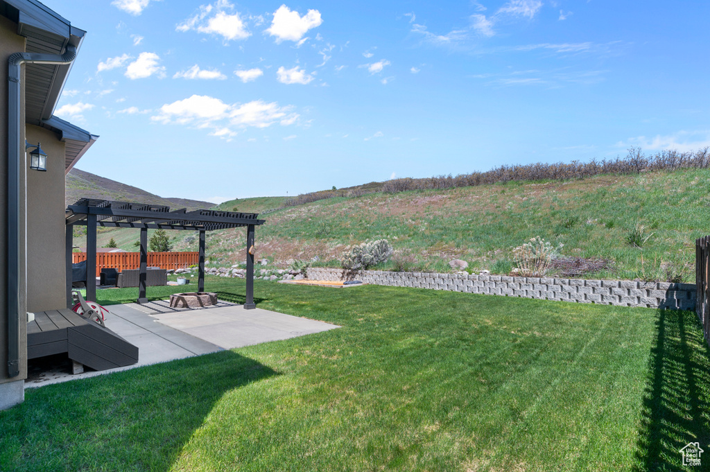 View of yard featuring a pergola, a patio, and a mountain view