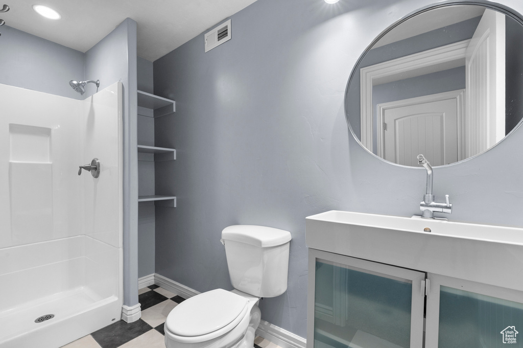Full bath with toilet, a shower stall, baseboards, and vanity