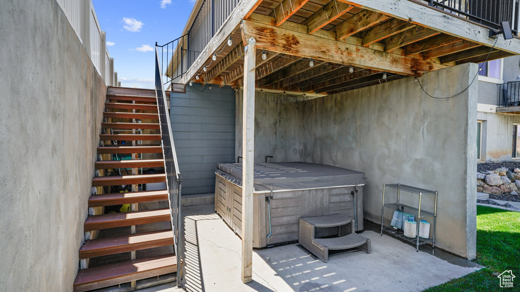 View of patio featuring a hot tub and stairway