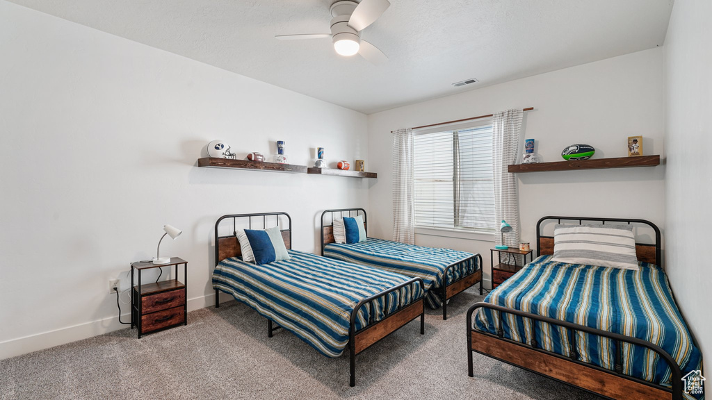 Carpeted bedroom featuring baseboards and a ceiling fan