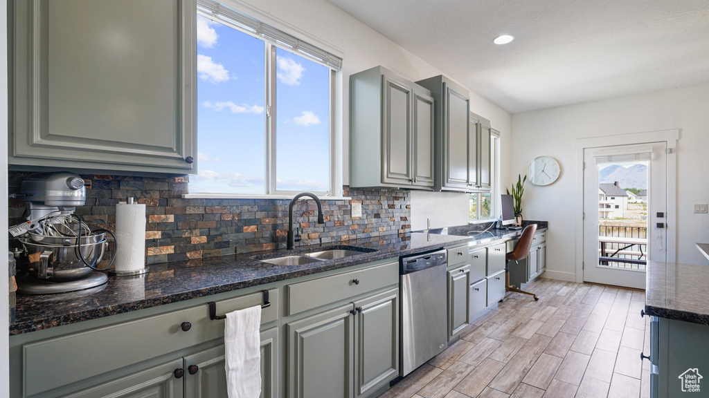 Kitchen with stainless steel dishwasher, a sink, gray cabinets, decorative backsplash, and recessed lighting