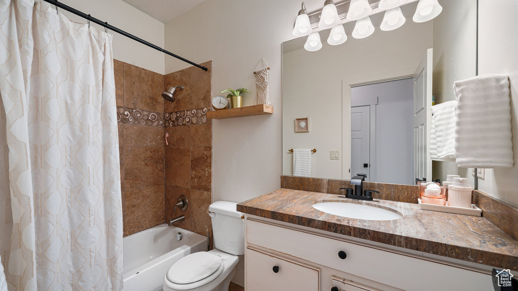 Full bath featuring shower / bathtub combination with curtain, vanity, and toilet