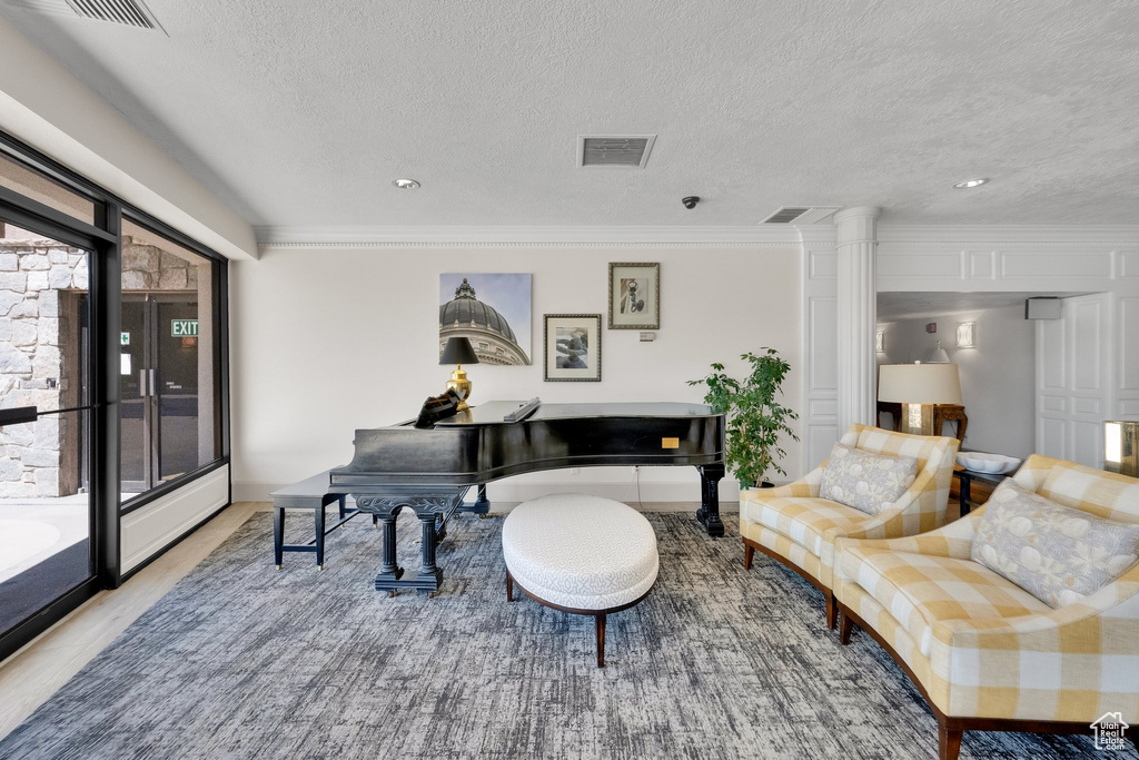 Living room featuring a textured ceiling, crown molding, and recessed lighting