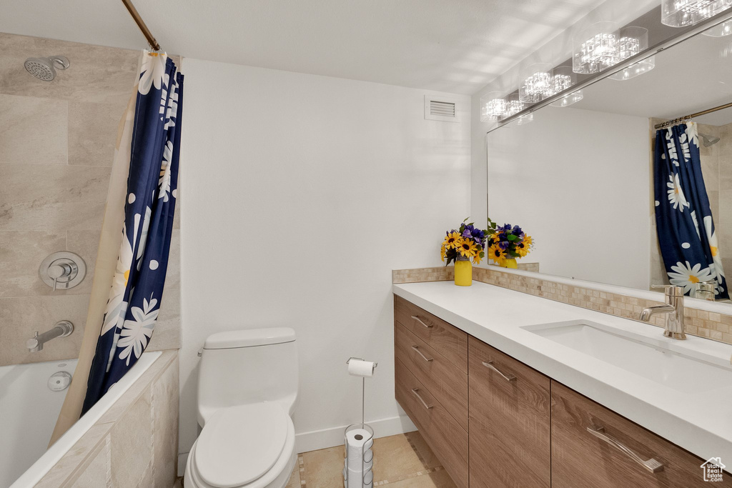 Full bath featuring toilet, vanity, tile patterned floors, and tiled shower / bath