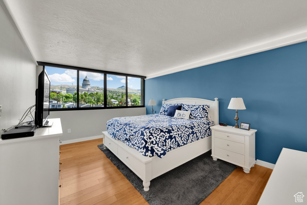 Bedroom featuring wood finished floors, baseboards, and a textured ceiling