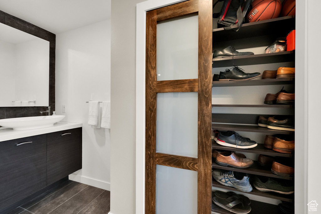 Bathroom featuring vanity, wood finished floors, and baseboards