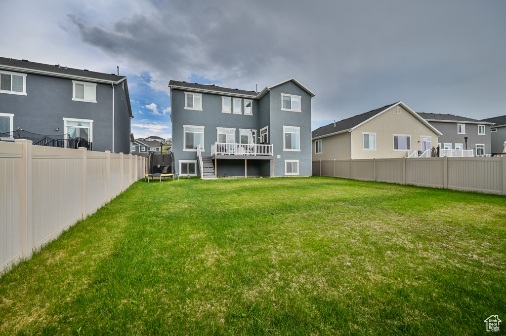 Back of property featuring a deck, a residential view, stucco siding, and stairway