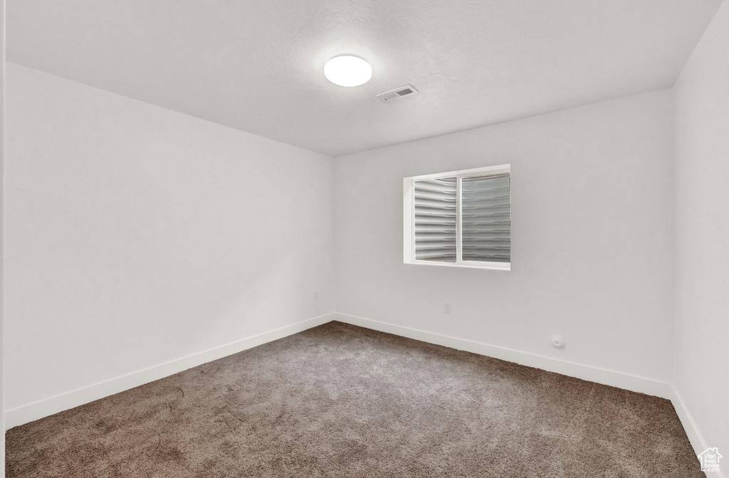 Spare room featuring carpet floors and baseboards