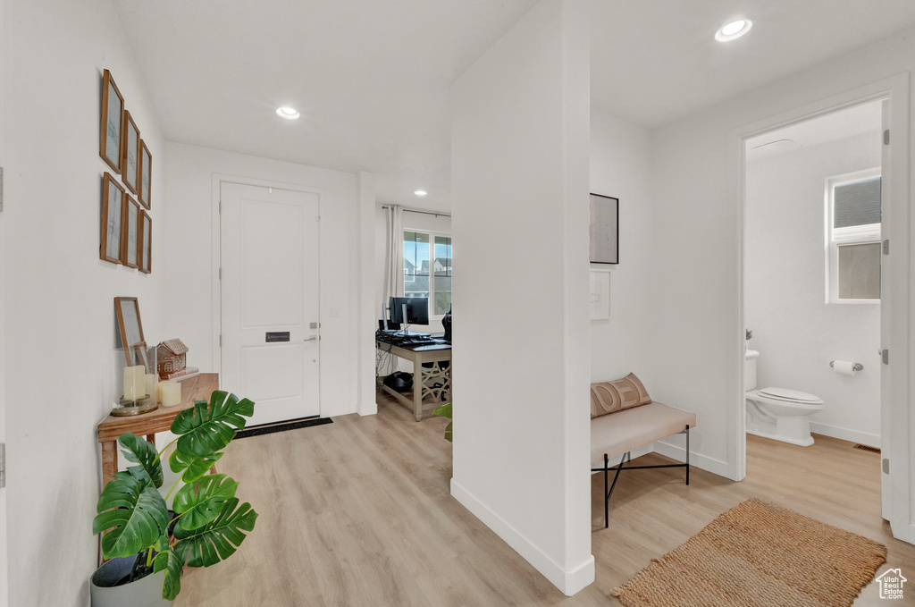 Hallway with light wood-type flooring, recessed lighting, and baseboards