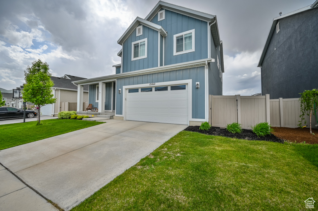 Traditional home with board and batten siding, a garage, and driveway